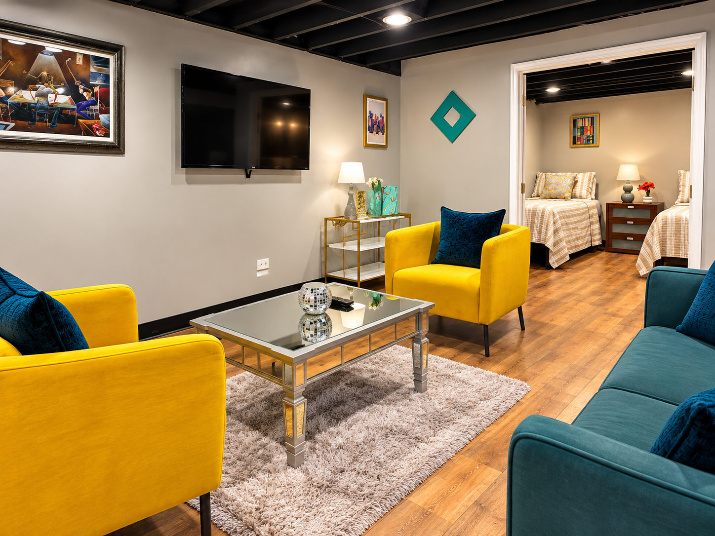 Living room — yellow chairs, teal sofa, glass coffee table, wall art